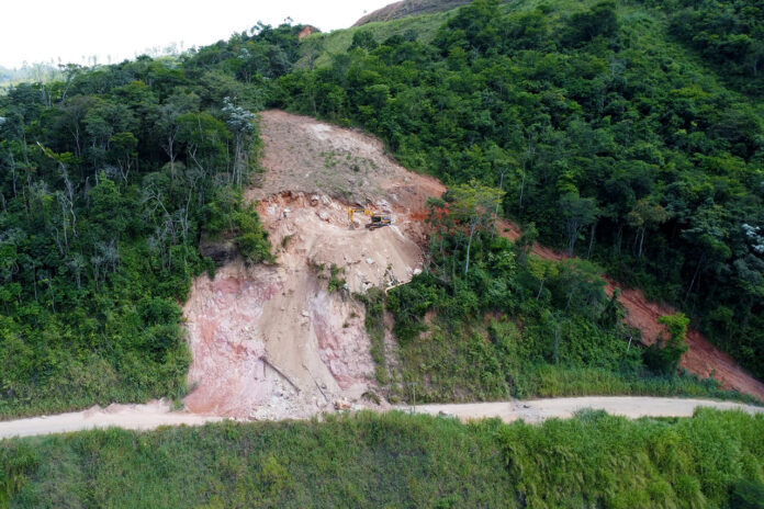 Prefeitura de João Monlevade e ArcelorMittal retomam obras para desobstrução da estrada do Jacuí A Prefeitura de João Monlevade e a ArcelorMittal retomaram esta semana as obras para desobstrução e recuperação da estrada do Jacuí. O trânsito no local precisou ser interditado para veículos e pedestres, devido ao risco de desmoronamento de pedras e da encosta rochosa. O trabalho consiste em quebrar as pedras maiores usando equipamentos pesados como retroescavadeiras e britadeiras mecânicas. Na segunda-feira (27) foi aberto um acesso íngreme ao lado do local do desmoronamento, onde as máquinas atuam retirando as rochas de cima para baixo. Segundo funcionários da ArcelorMittal, até o final da semana, esse processo de remoção das rochas deve ser concluído. A próxima etapa será a retirada de todo o material da pista. Toda a terra e rochas removidas serão levadas para uma área no Distrito Industrial da cidade. O prefeito de João Monlevade, Dr. Laércio Ribeiro (PT), o vice e secretário municipal de Planejamento e Desenvolvimento Econômico, Fabrício Lopes (Avante), estiveram na estrada do Jacuí acompanhando os trabalhos. O chefe do Executivo reiterou que a administração municipal e a ArcelorMittal estão empenhadas em liberar, com segurança, o acesso da via o quanto antes. “Sabemos que a estrada é importante para o deslocamento dos nossos cidadãos e para o transporte de mercadorias. Por isso estamos empenhados em resolver o problema o mais rápido possível. Pedimos a compreensão de todos e reforçamos que estamos trabalhando para garantir a segurança e mobilidade de toda comunidade