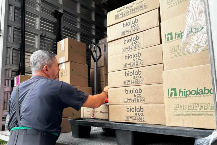 Homem tira caixas de caminhão com os medicamentos.