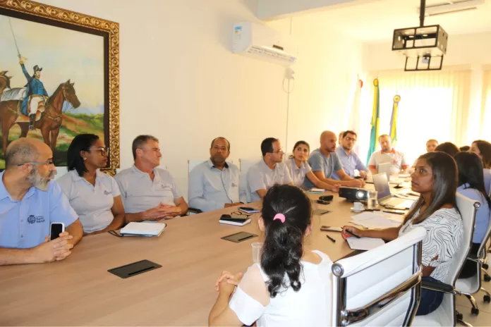 Membros do Poder Executivo e Legislativo reunidos em reunião.