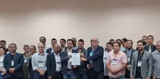 Membros reunidos para foto com o documento de não assinatura em mãos.