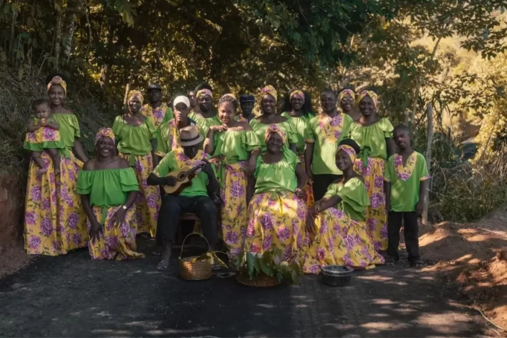 Membros da comunidade vestidos com trajes culturais de sua região e posando para uma foto.