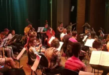 Estudantes reunidos em aula da escola de música.