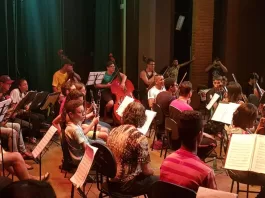 Estudantes reunidos em aula da escola de música.