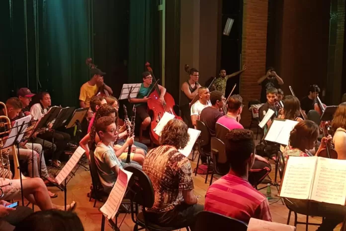 Estudantes reunidos em aula da escola de música.